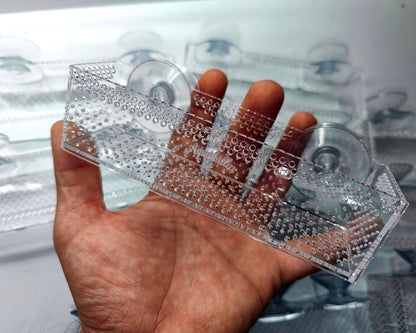 Lange Aquakallax Bucen-Box mit gelochtem Boden und zwei Saugnäpfen in schräger Ansicht in der Hand
