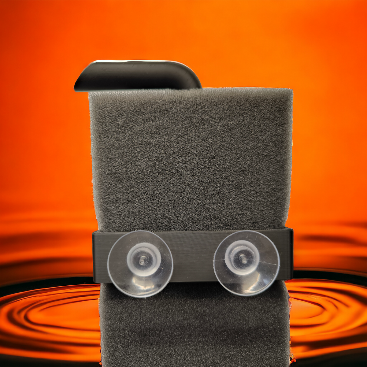 Aquakallax HMF-Schwammfilter mit schwarzem Halter und zwei transparenten Saugnäpfen vor orangefarbenem Wasserhintergrund.