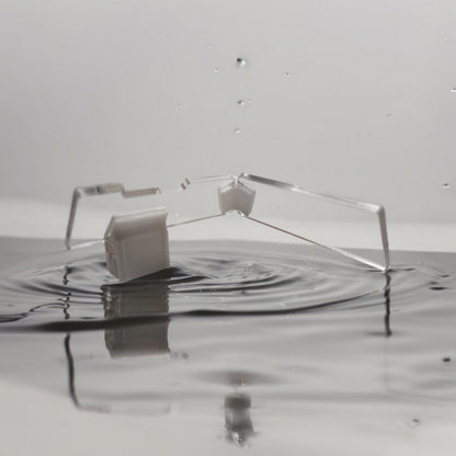 Transparente Aquakallax JumpStop Sprungschutzecken mit weißen Klemmhaltern in flacher Seitenansicht vor Wasserhintergrund