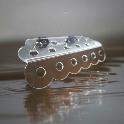 Transparenter Aquakallax ReefDeck für 17 Korallenplugs in Bubble-Form mit runden Öffnungen und zwei Magnethaltern vor Wasserhintergrund