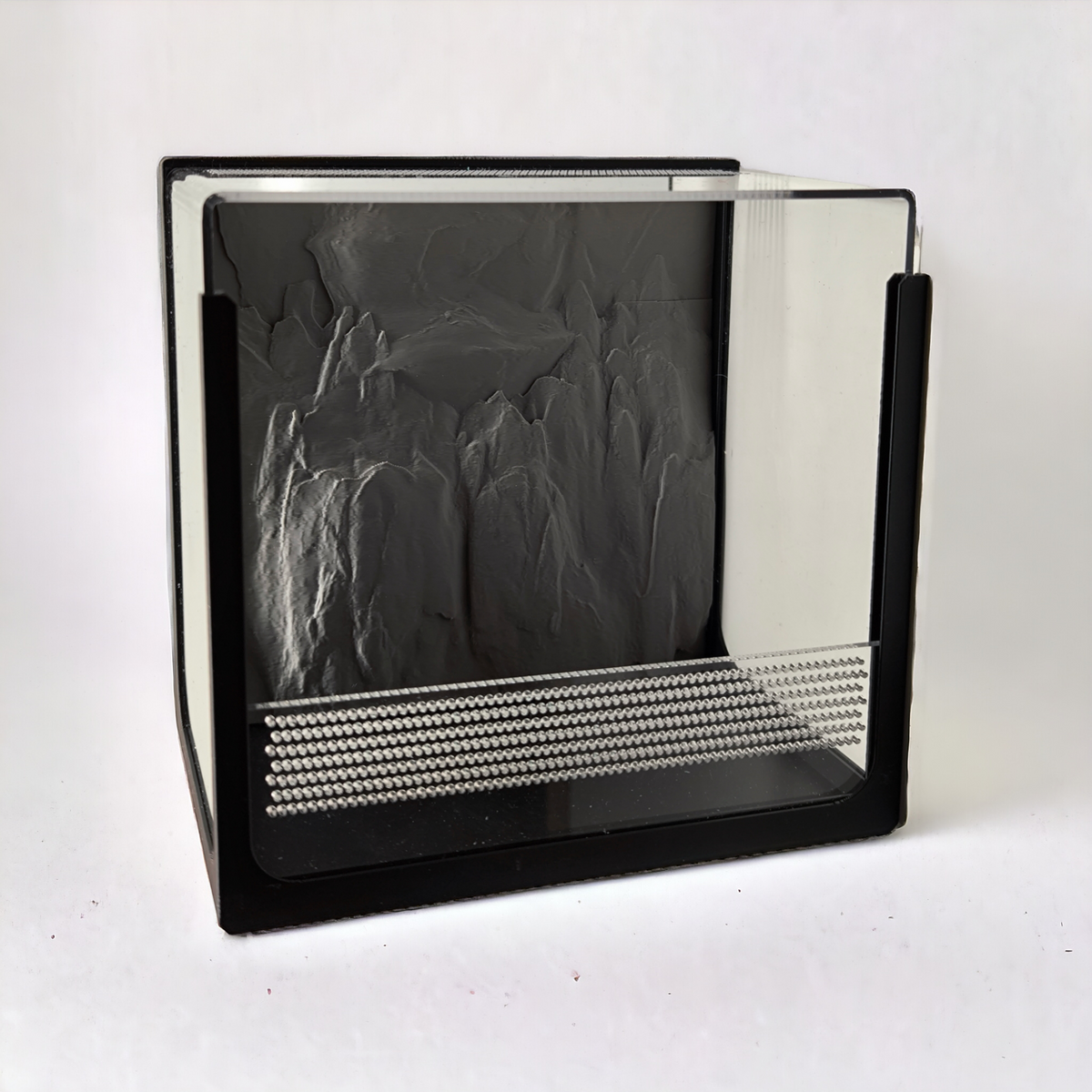 Aquakallax Terrakallax Terrarium mit schwarzem Rahmen, transparenter Front und grauer Felsrückwand in schräger Ansicht